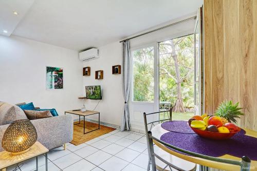 una sala de estar con una mesa con un bol de fruta. en Le Vakoa - Saint Gilles les Bains, en Saint-Gilles-les-Bains