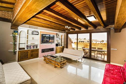 uma sala de estar com um sofá e uma televisão em Casa Rural Spa La Chirumba em Aldeatejada