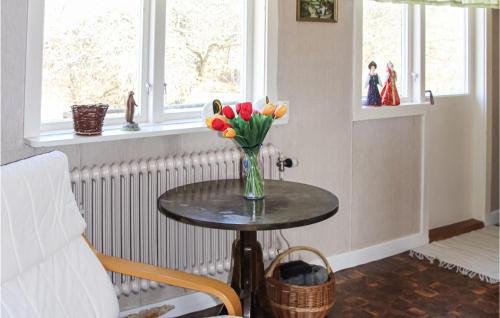 a vase of flowers on a table in a room at Awesome Home In Torup With Wifi in Torup