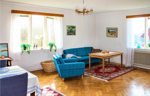 a living room with a blue couch and a table at Awesome Home In Torup With Wifi in Torup