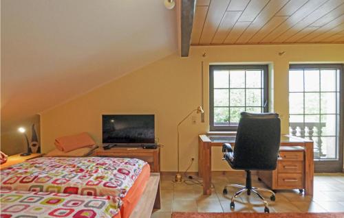 a bedroom with a bed and a desk and a computer at 2 Bedroom Cozy Apartment In Karlshausen in Karlshausen