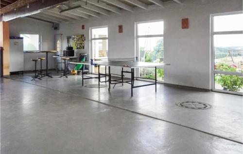 an empty room with tables and chairs and windows at 2 Bedroom Cozy Apartment In Karlshausen in Karlshausen