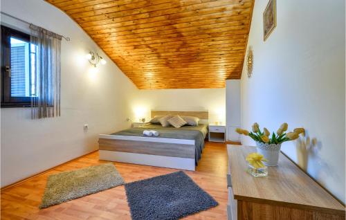 a bedroom with a bed and a wooden ceiling at 2 Bedroom Gorgeous Home In Gornje Stative in Gornje Stative