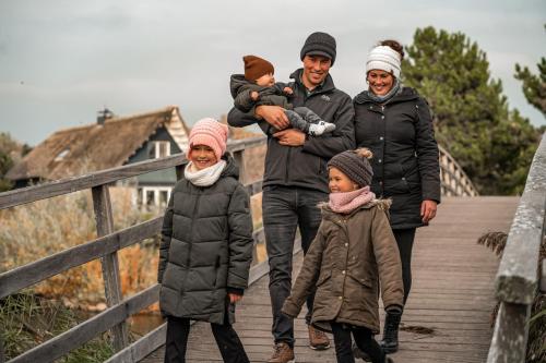 a family walking down a wooden bridge at Beach Resort Makkum in Makkum