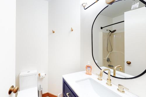 Un baño con lavabo y un espejo grande. en Trail Creek Unit 44, en Killington