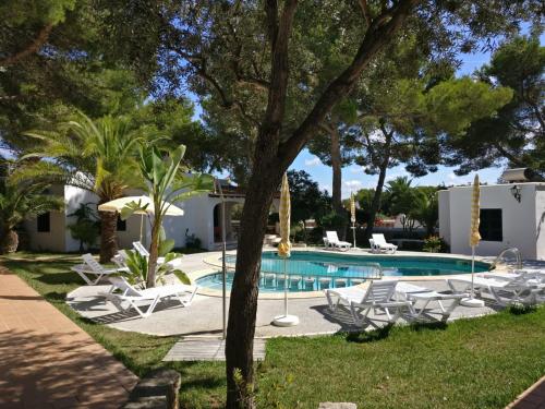 a swimming pool with lounge chairs and a resort at Apartamentos Playa Calan Blanes in Cala en Blanes