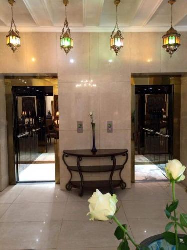 a lobby with a table with a vase on it at Shanasheel Palace Hotel in Baghdad
