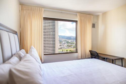 a hotel room with a bed and a large window at Four Paddle Condominium 2210 Thirty plus night rental in Honolulu