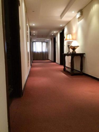 an empty hallway with a desk and a lamp on a table at Shanasheel Palace Hotel in Baghdad