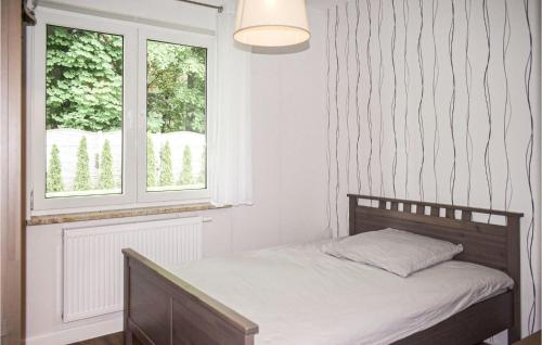 a small bedroom with a bed and a window at Awesome Home In Wrzosowo With 2 Bedrooms And Wifi in Wrzosowo