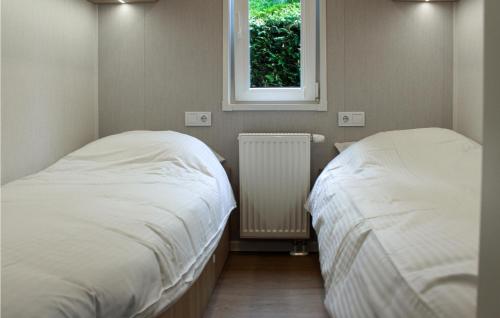 two beds in a small room with a window at Nice stacaravan In Marienberg With Kitchen in Mariënberg