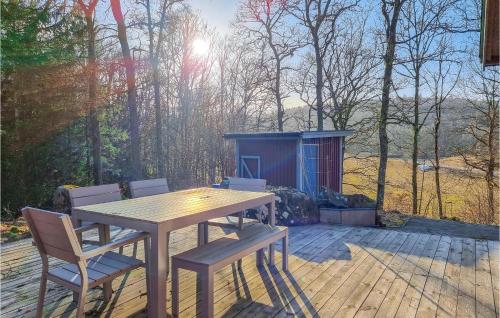 a wooden table and chairs on a deck with a shed at Beautiful Home In Yngered With Wifi in Yngered