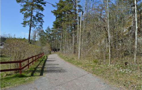 a dirt road with a fence and trees at 4 Bedroom Nice Home In Trosa in Trosa