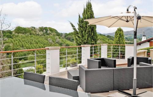 a balcony with chairs and an umbrella and a view at Lovely Home In Saint-Pée-Sur-Nivelle in Saint-Pée-sur-Nivelle