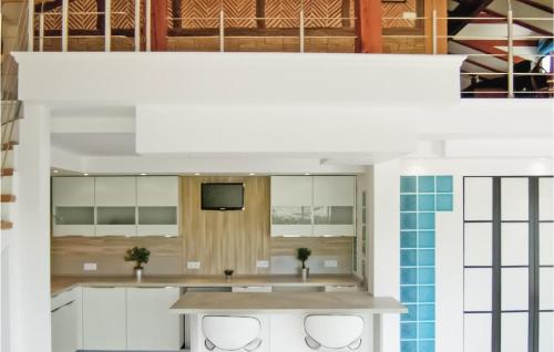サン・ペ・シュル・ニヴェルにあるBeautiful Home In Saint-pe-sur-nivelle With 2 Bedrooms, Wifi And Outdoor Swimming Poolの白いキャビネットと壁掛けテレビ付きのキッチン