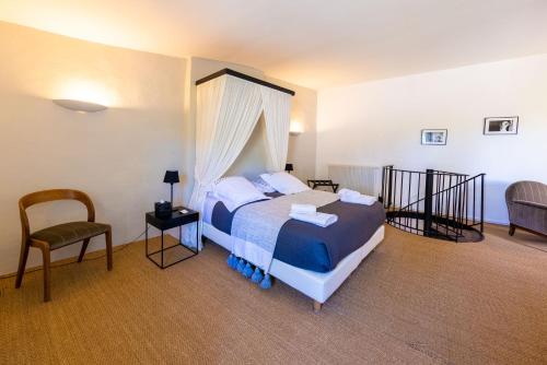 - une chambre avec un lit et une chaise dans l'établissement Monte Arena Chambre d'hôtes, à Montaren-et-Saint-Médiers