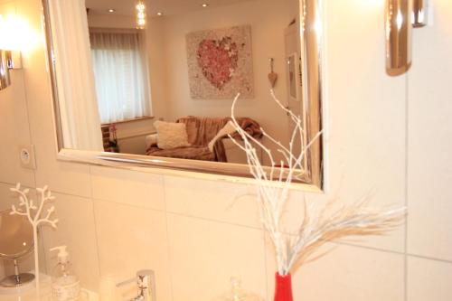 a bathroom with a mirror and a dog in a couch at Au Coeur Des Hôtes in Steenvoorde
