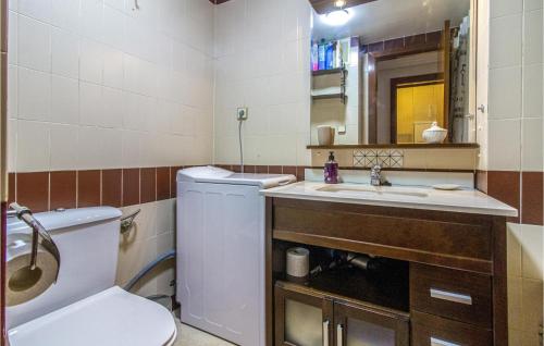 a bathroom with a toilet and a sink and a mirror at Amazing Apartment In Benidorm With Outdoor Swimming Pool, Swimming Pool And 1 Bedrooms in Benidorm