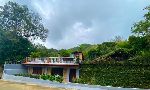 a house with a balcony on top of it at Finca Villa Chalet Del Rio Cali Farm Villa Chalet Cali River in Cali