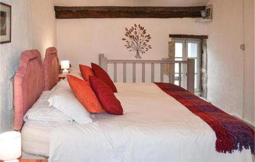 ein Schlafzimmer mit einem großen Bett mit roten Kissen in der Unterkunft Amazing Home In Lusignac With Outdoor Swimming Pool in Lusignac