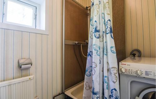 a bathroom with a shower curtain next to a washing machine at Nice Home In Munkedal With Lake View in Munkedal