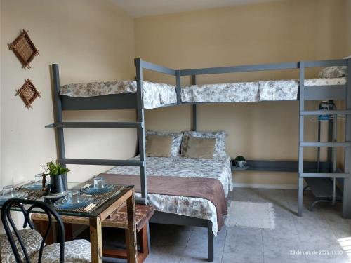 a bedroom with two bunk beds and a table at Apartamentos Capri Beach House Residencial Familiar in São Francisco do Sul