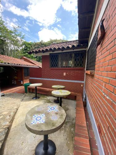 a patio with two tables and a brick wall at Finca Villa Chalet Del Rio Cali Farm Villa Chalet Cali River in Cali
