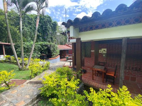 a patio of a house with a table and chairs at Finca Villa Chalet Del Rio Cali Farm Villa Chalet Cali River in Cali