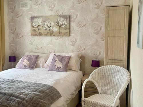 a bedroom with a bed and a chair at The Bay Cottage in Thornton