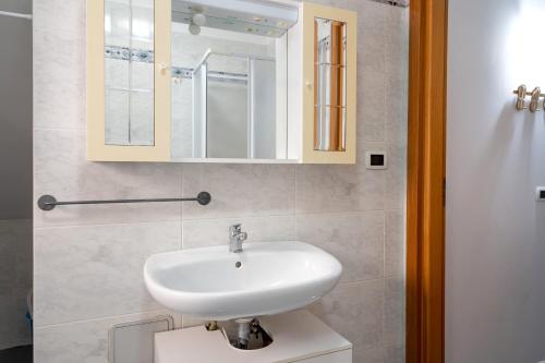 a bathroom with a white sink and a mirror at A casa di Pietro Quattro in Leporano