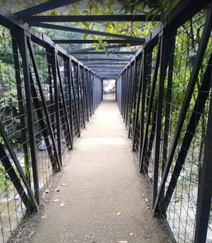 a black fence with a walkway through a forest at Finca Villa Chalet Del Rio Cali Farm Villa Chalet Cali River in Cali
