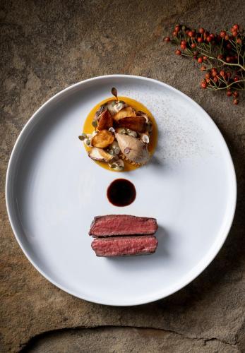 a plate of food with meat and sauce on it at Klosterhof – Alpine Hideaway & Spa in Bad Reichenhall
