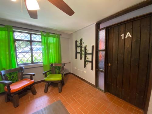 a room with two chairs and a door with green curtains at Finca Villa Chalet Del Rio Cali Farm Villa Chalet Cali River in Cali