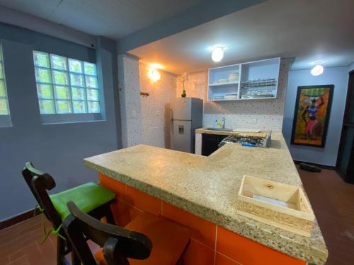 a kitchen with a counter and a refrigerator at Finca Villa Chalet Del Rio Cali Farm Villa Chalet Cali River in Cali