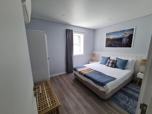 a bedroom with a king sized bed with blue walls at As Casas da Vinha in Criação Velha