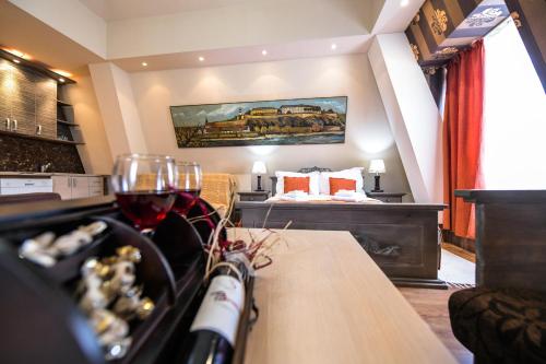 Habitación con cama y mesa con copas de vino en Vila Hit, en Ruma
