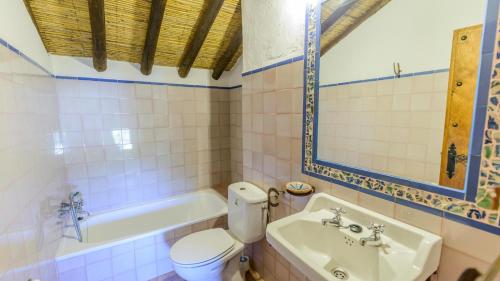 y baño con aseo, bañera y lavamanos. en El Morrón Algarinejo by Ruralidays en Algarinejo