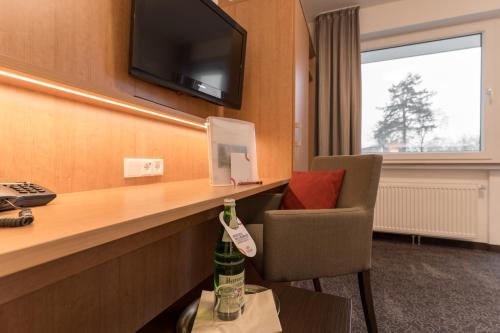 a hotel room with a desk with a bottle of wine at Hotel Villa Dürkopp in Bad Salzuflen