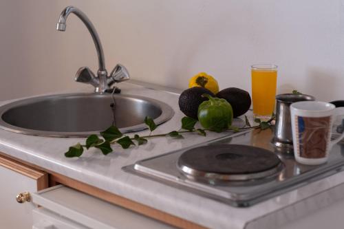 um lavatório com um prato e fruta e um copo de sumo de laranja em Krinos apartment 1 