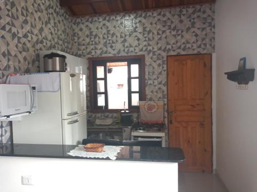 a kitchen with a refrigerator and a counter top at Apts centro Ubatuba in Ubatuba