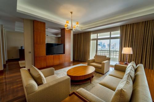 a living room with a couch and a table at Grand Hyatt Doha Hotel & Villas in Doha