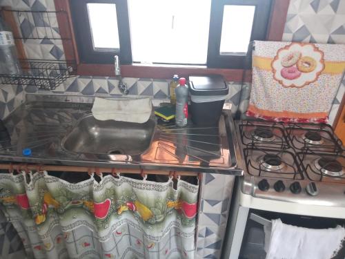 a kitchen counter with a sink and a stove at Apts centro Ubatuba in Ubatuba