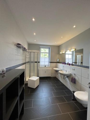 a bathroom with two sinks and two toilets at Sonneneck Ferienwohnungen adults only in Braunlage