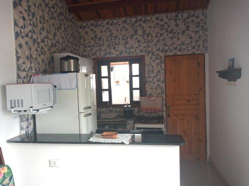 a kitchen with a refrigerator and a microwave at Apts centro Ubatuba in Ubatuba