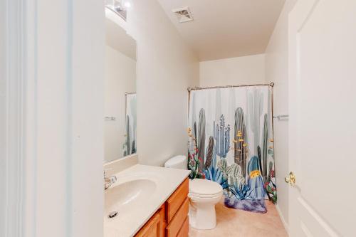 a bathroom with a toilet and a shower curtain at North Twin Lakes Abode in Catalina