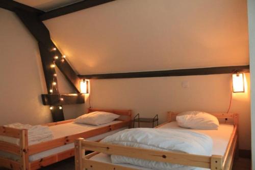 two beds in a room with lights on the wall at -Le Petit Mouton- Spacieux logement centre ville in Argenton-sur-Creuse