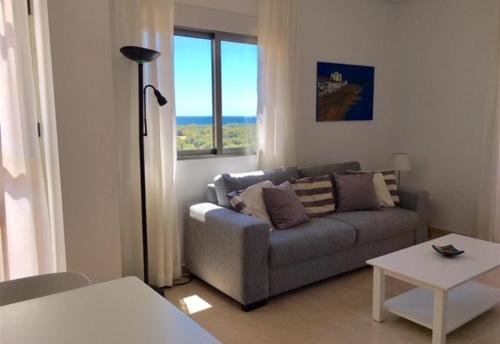 una sala de estar con un sofá y una mesa en Cozy bright apartment, en Guardamar del Segura
