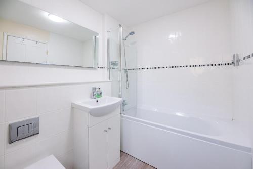 a white bathroom with a sink and a shower at The Nest Aldeburgh Air Manage Suffolk in Aldeburgh