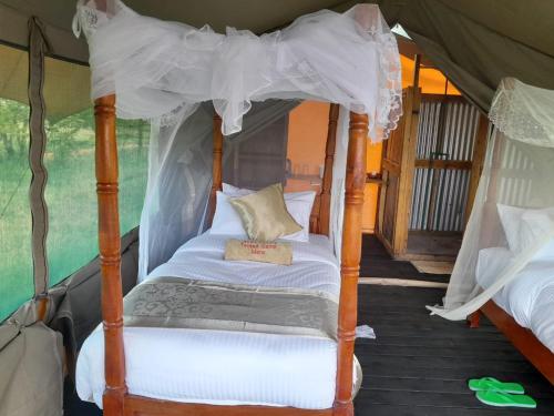 a four poster bed in a tent at Sonkoi Tent Safari Camp in Narok