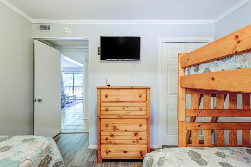 a bedroom with a bed and a dresser and a tv at HH Beach & Tennis 7A in Hilton Head Island